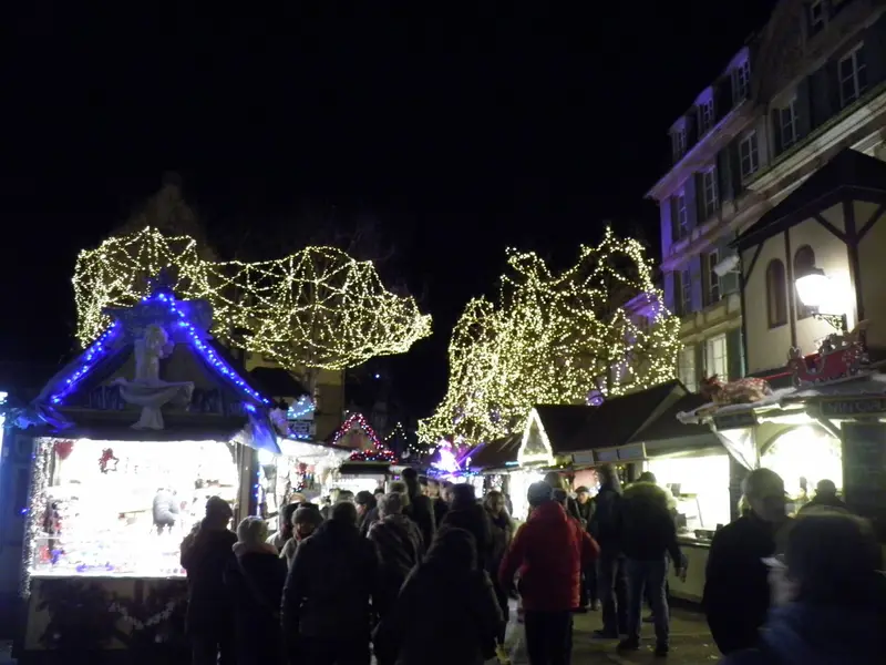 Chalets illuminés du marché de Noël de la place Jeanne-d’Arc, à Colmar, le soir